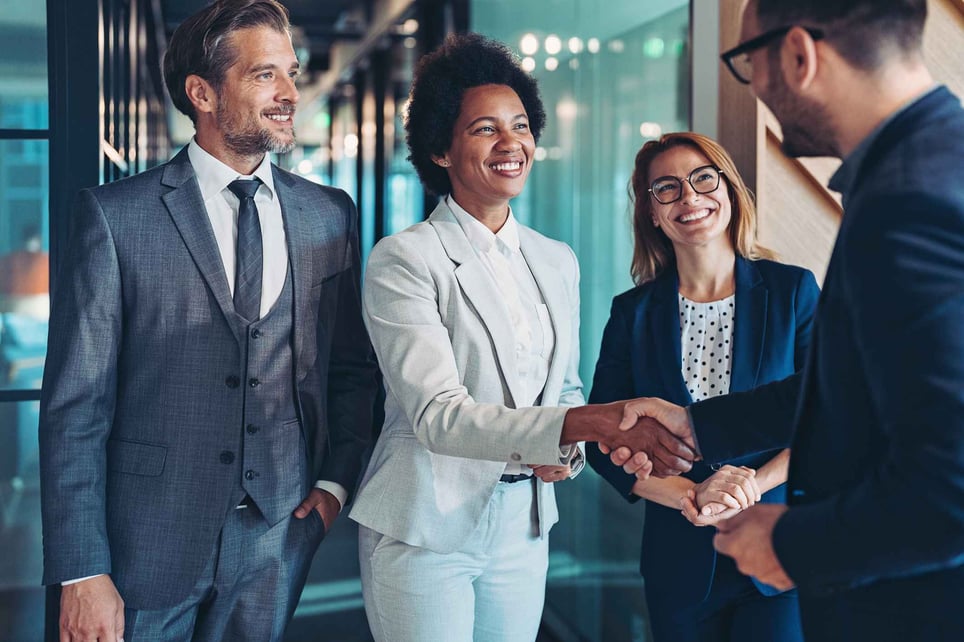 Woman-being-congratulated-by-coworkers-promotion-announcement