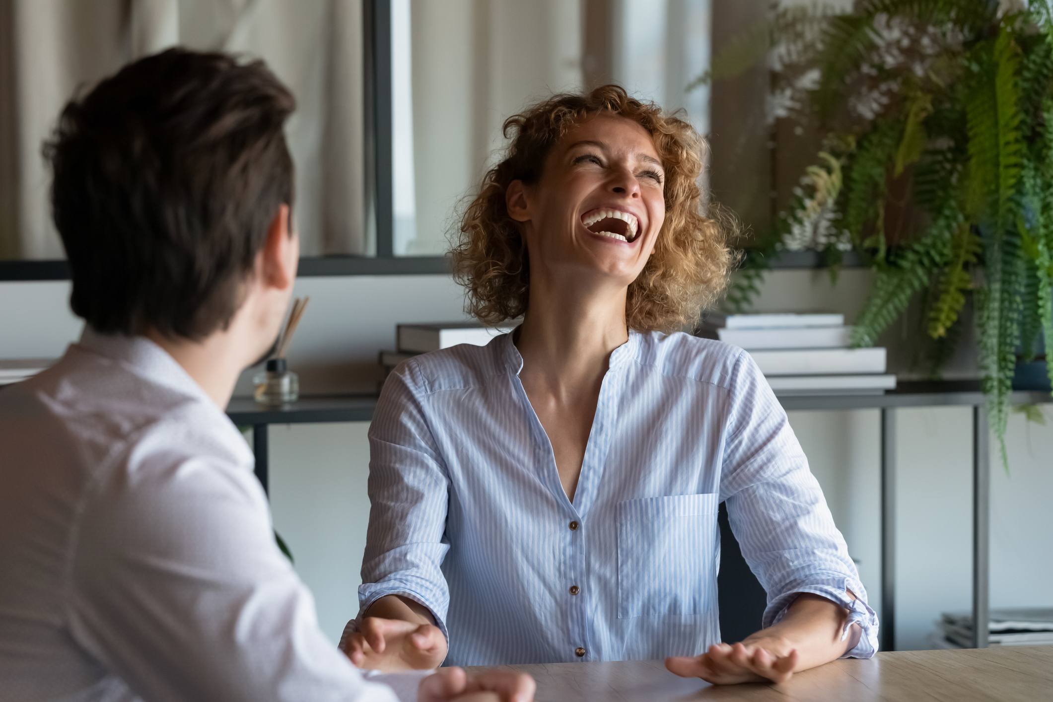 Woman-laughing-with-man-she-is-interviewing-for-work-interview-bias