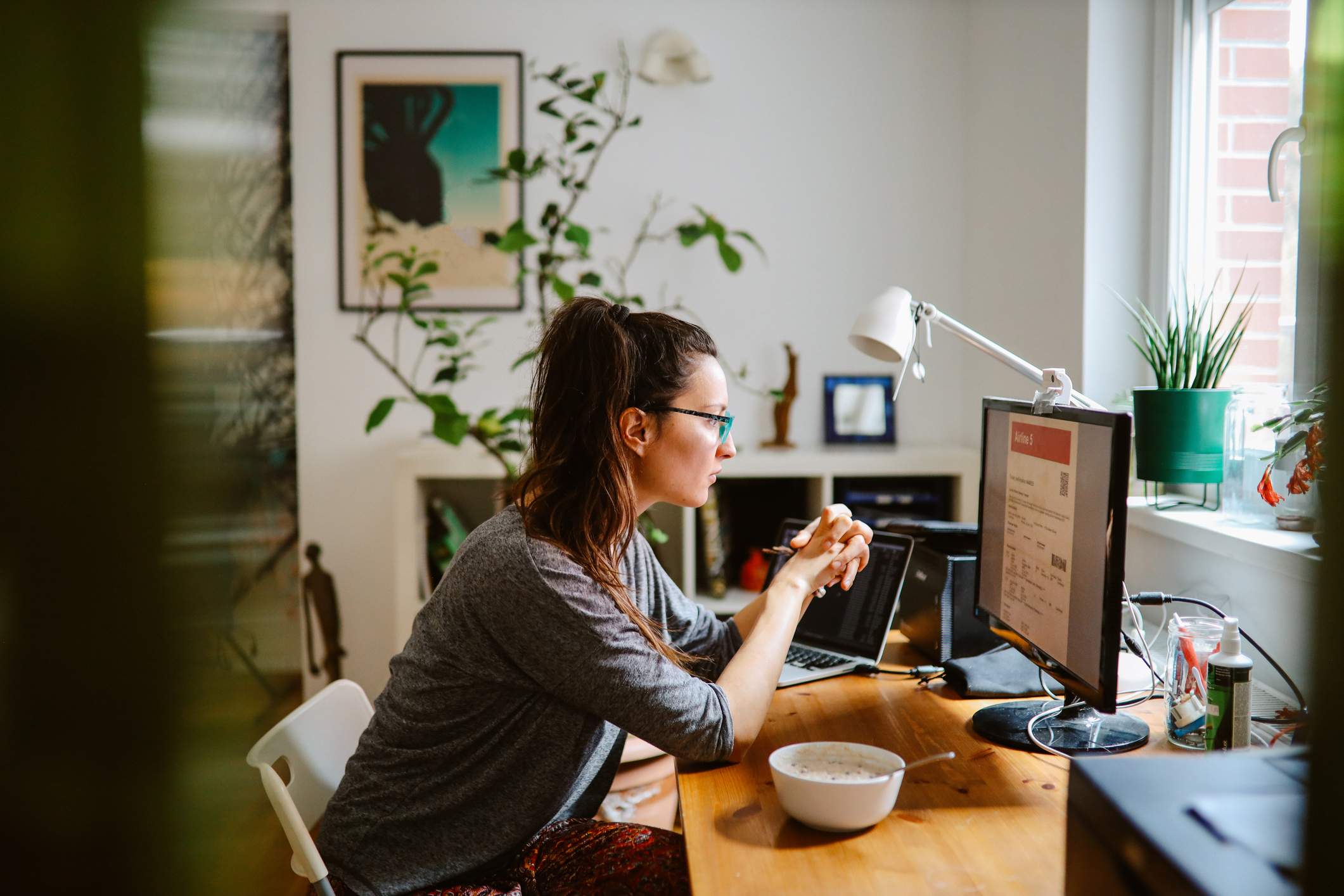 Woman-looking-at-invoice-in-computer-while-working-remotely-why-is-there-a-labor-shortage