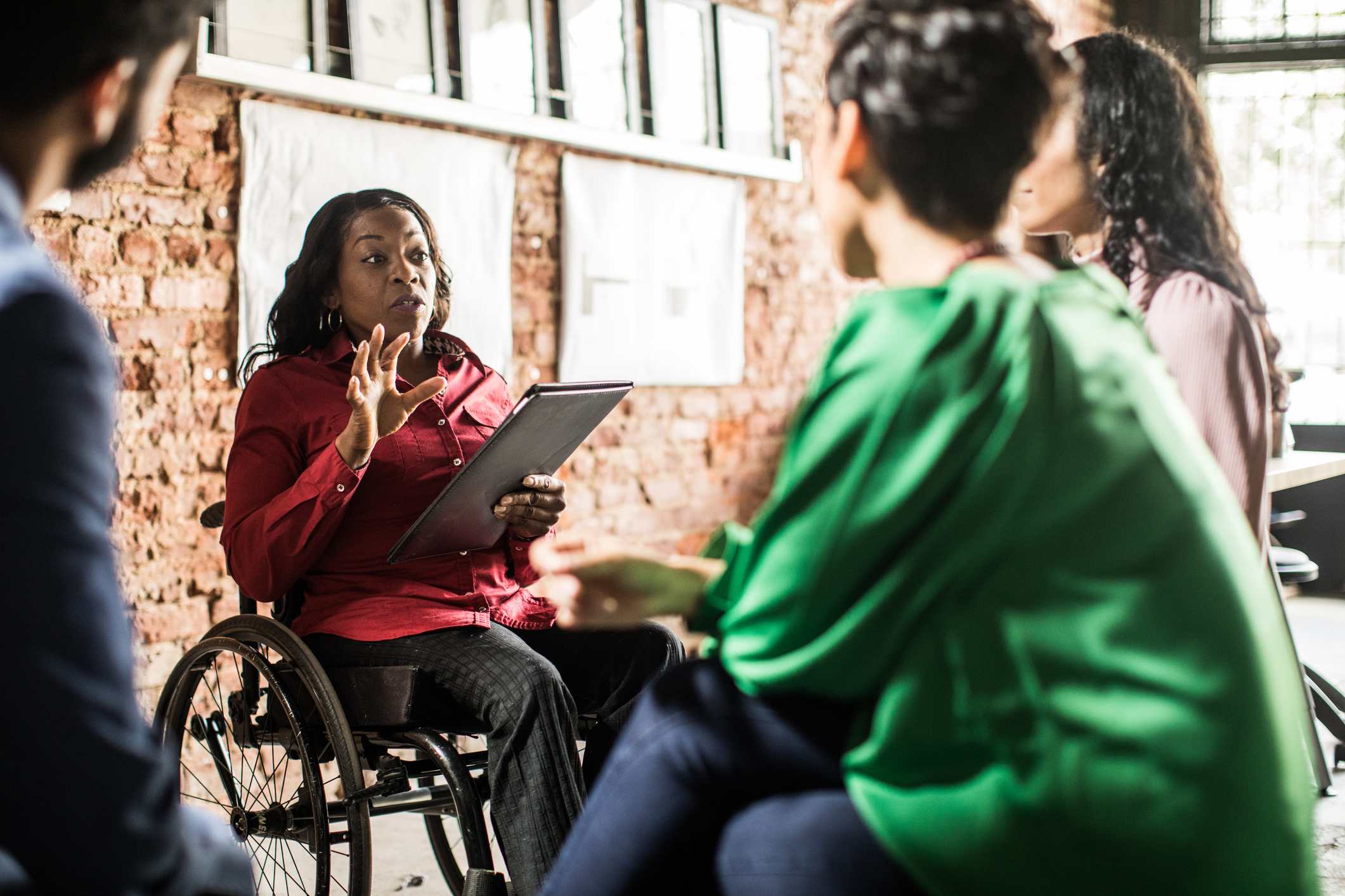 Woman-on-a-wheelchair-giving-course-to-collegues-at-office-interview-bias