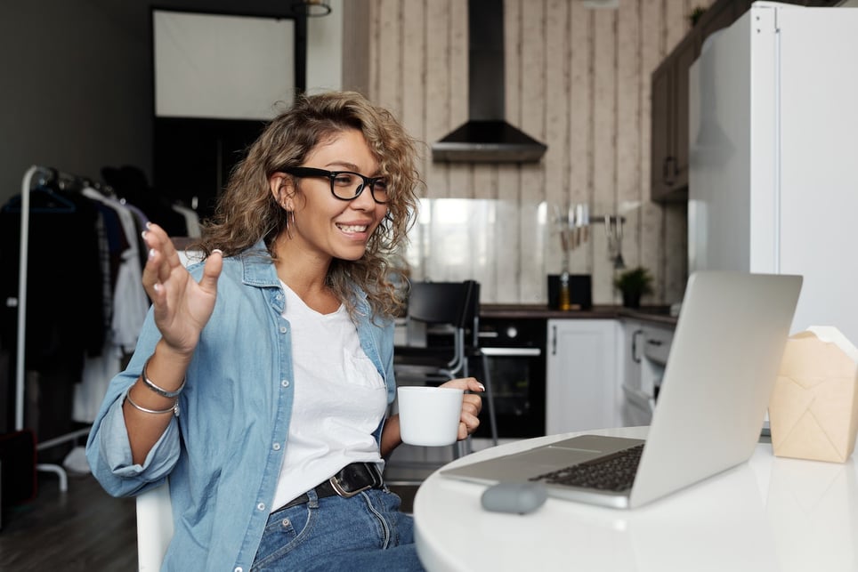 Woman-on-videocall-smiling-with-coffee-cup-on-hand-how-to-wake-yourself-up