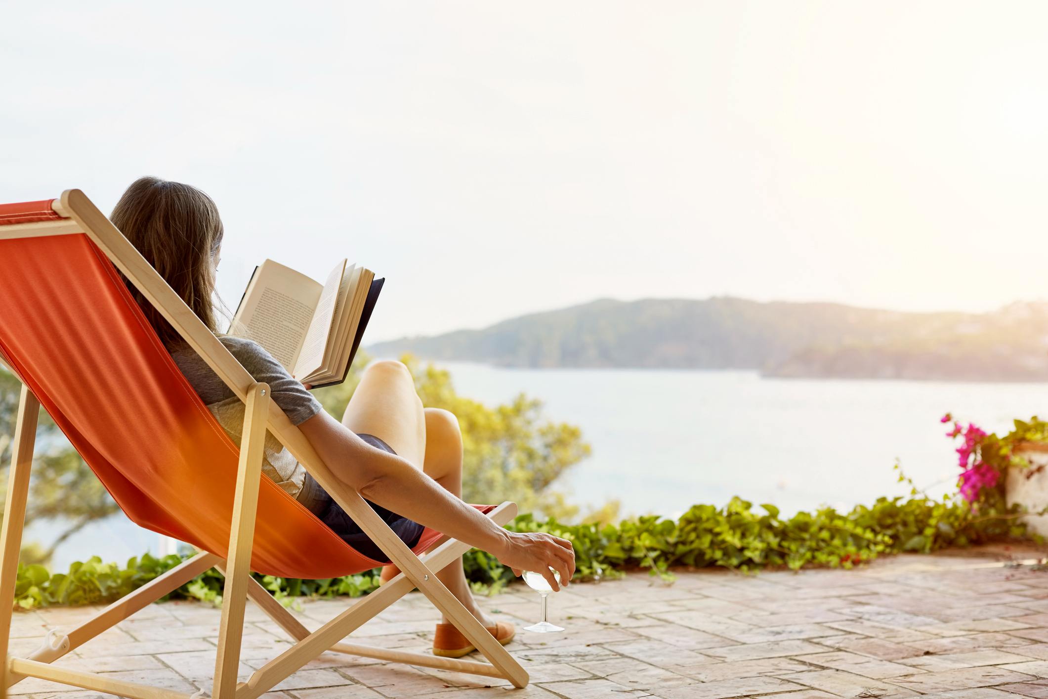 Woman-reading-book-while-relaxing-on-deck-the-importance-of-taking-breaks