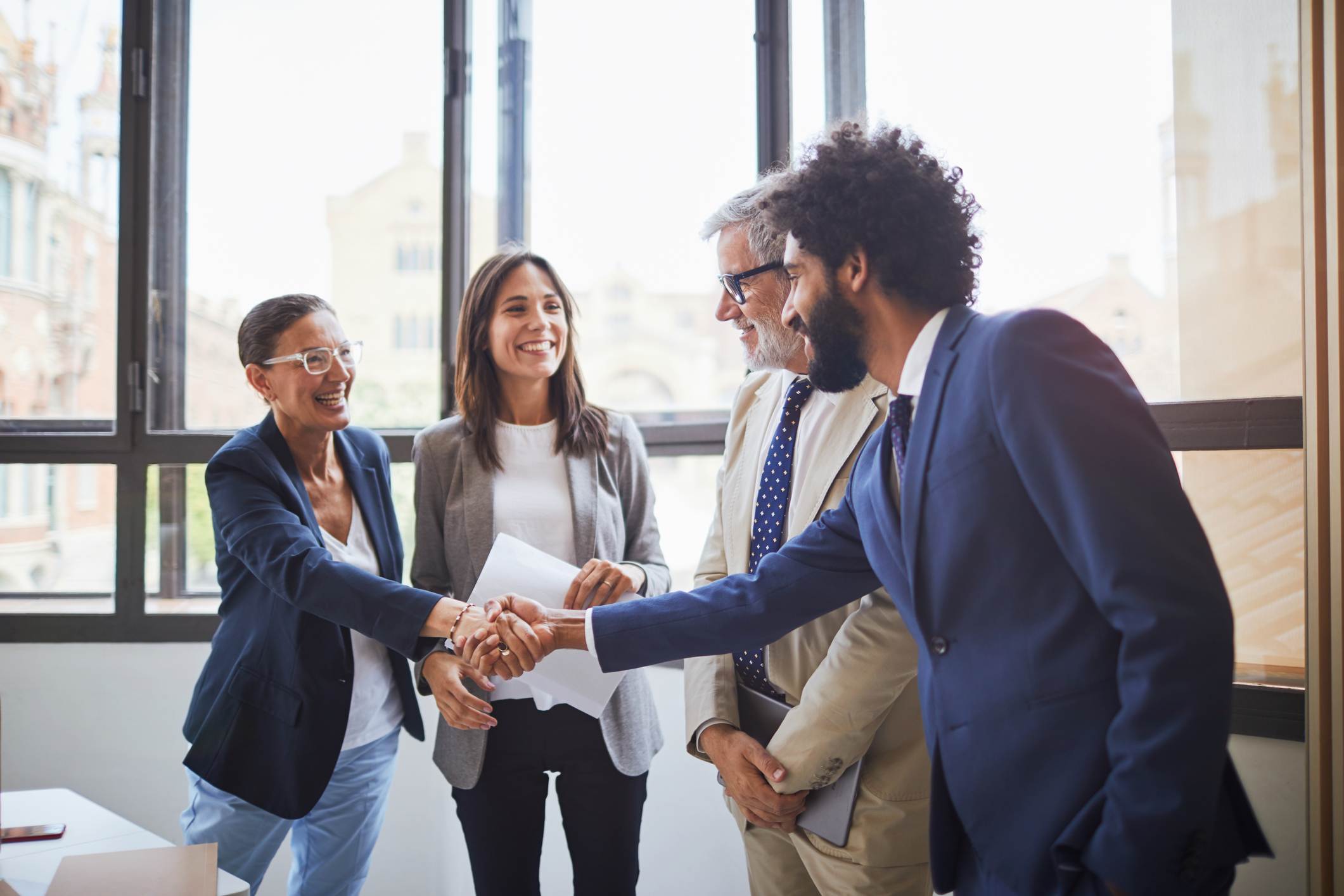 Woman-shaking-coworkers-hand-at-office-is-it-better-to-be-fired-or-quit