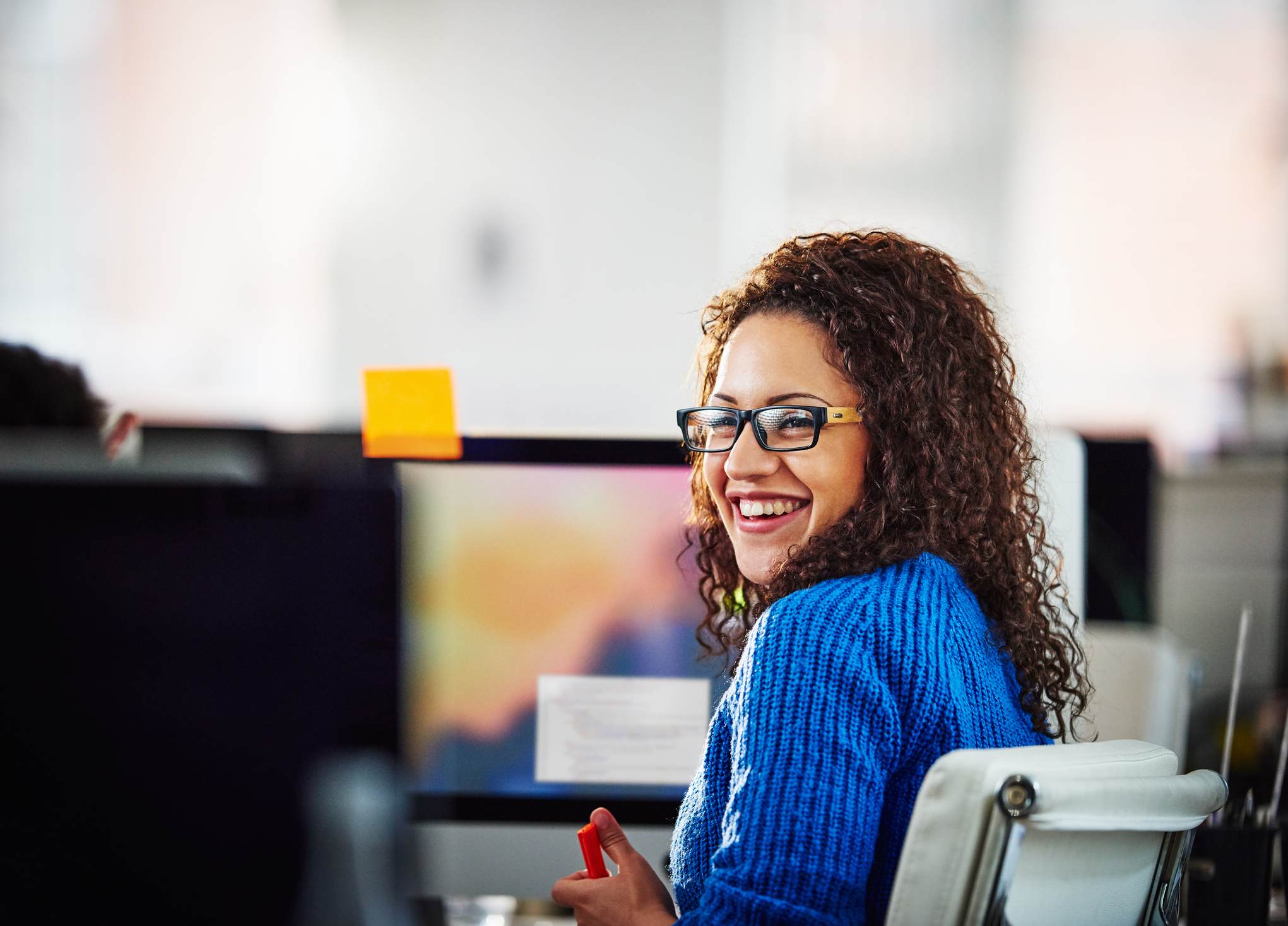 Woman-smiling-to-coworker-at-her-desk——第一天上班