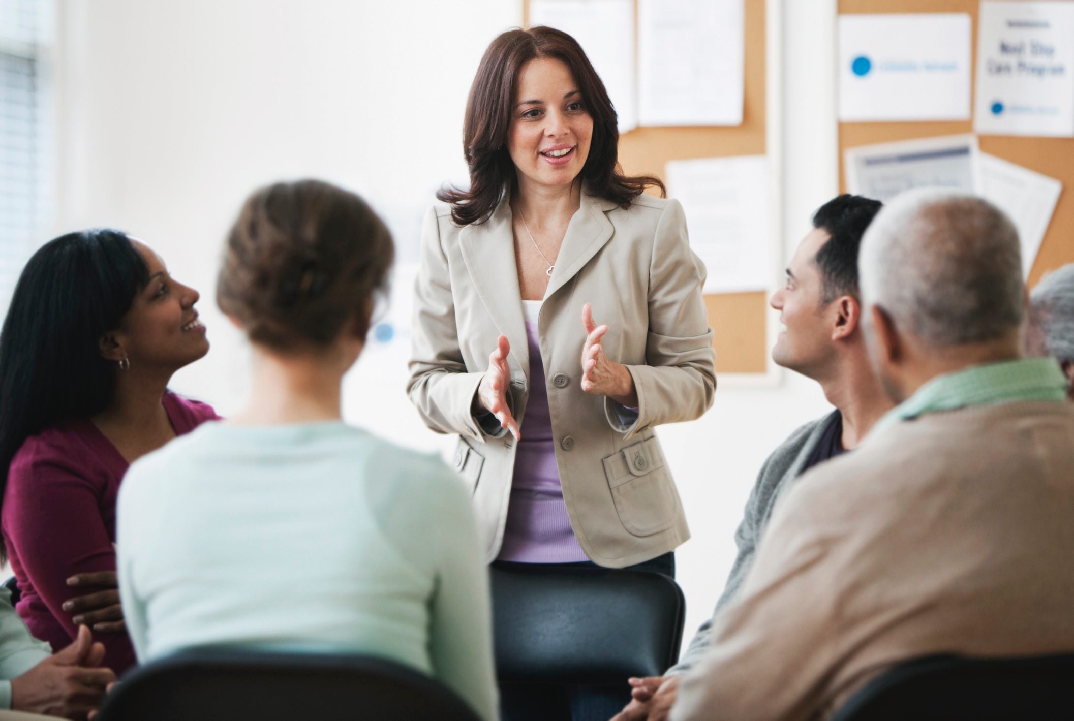 Woman-smiling-while-presenting-topic-to-diverse-group-of-coworkers-cognitive-empathy