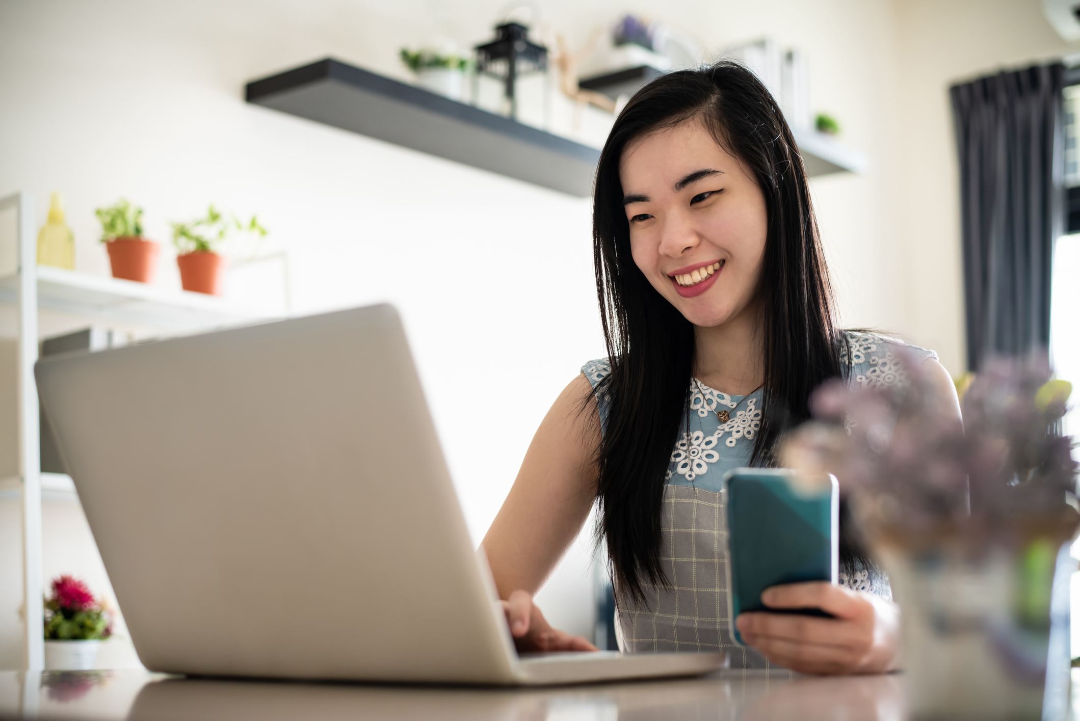 Woman-smiling-while-writing-email-how-to-congratulate-someone-on-a-promotion