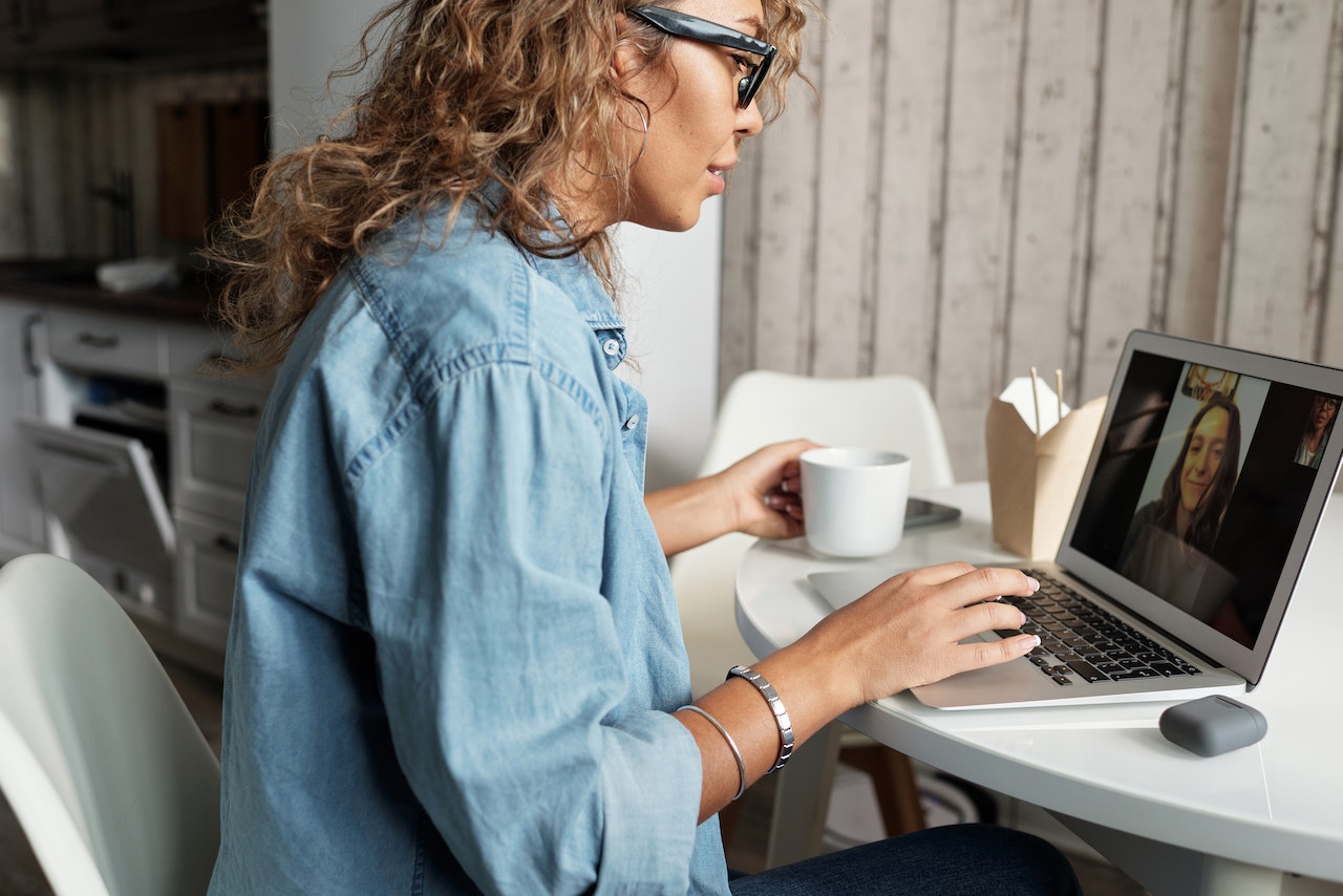 Woman-talking-and-holding-cup-of-coffee-on-videocall-virtual-interview