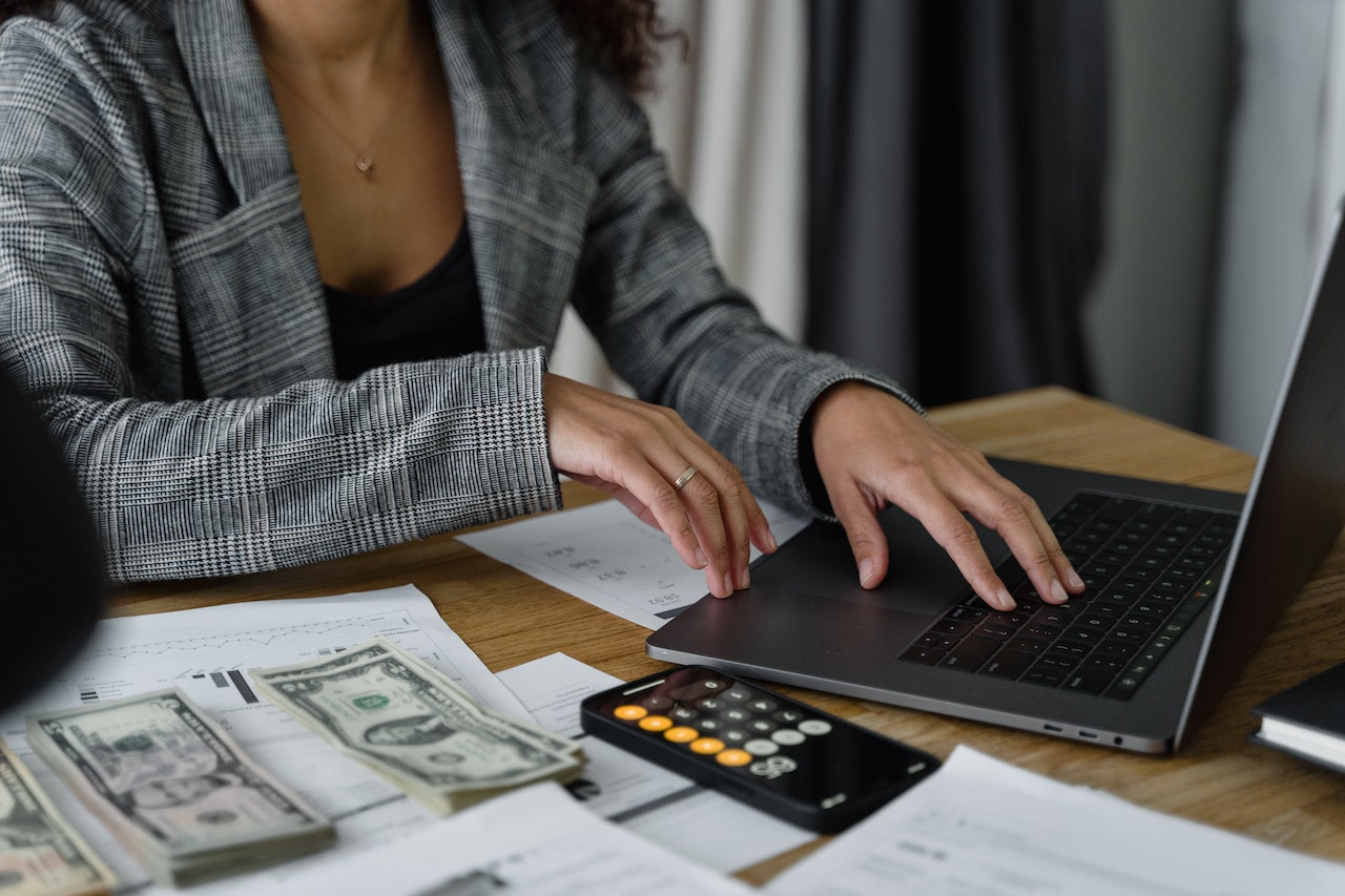 Woman-using-calculator-with-money-besides-her-how-to-budget