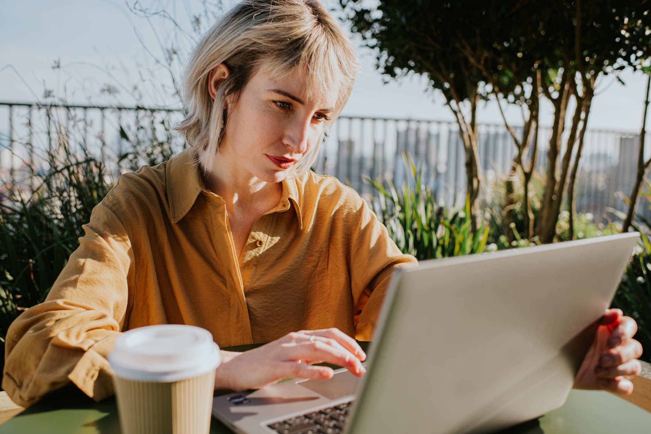 Woman-writing-email-on-her-laptop-outdoors-email-before-first-day-of-work