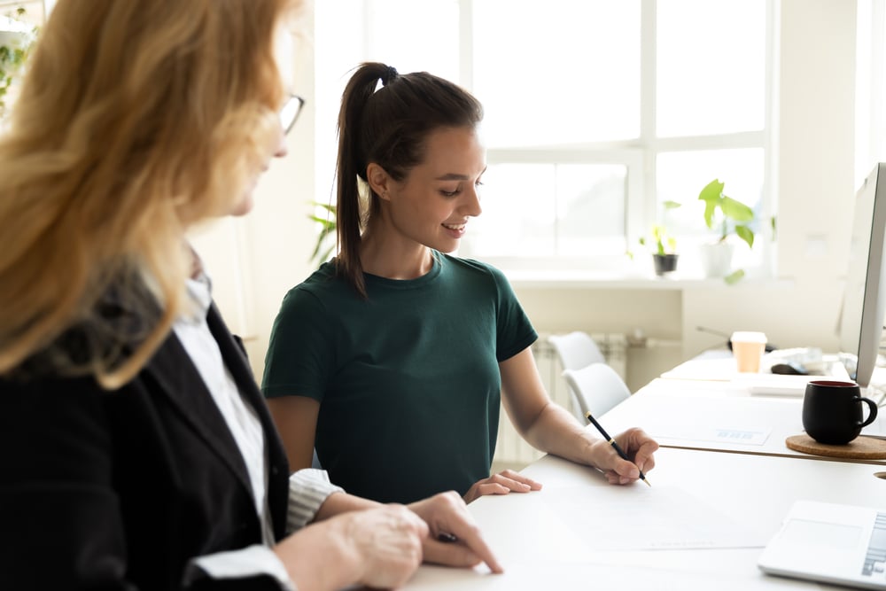 Woman-writing-letter-with-help-of-coworker-personal-reason-leave