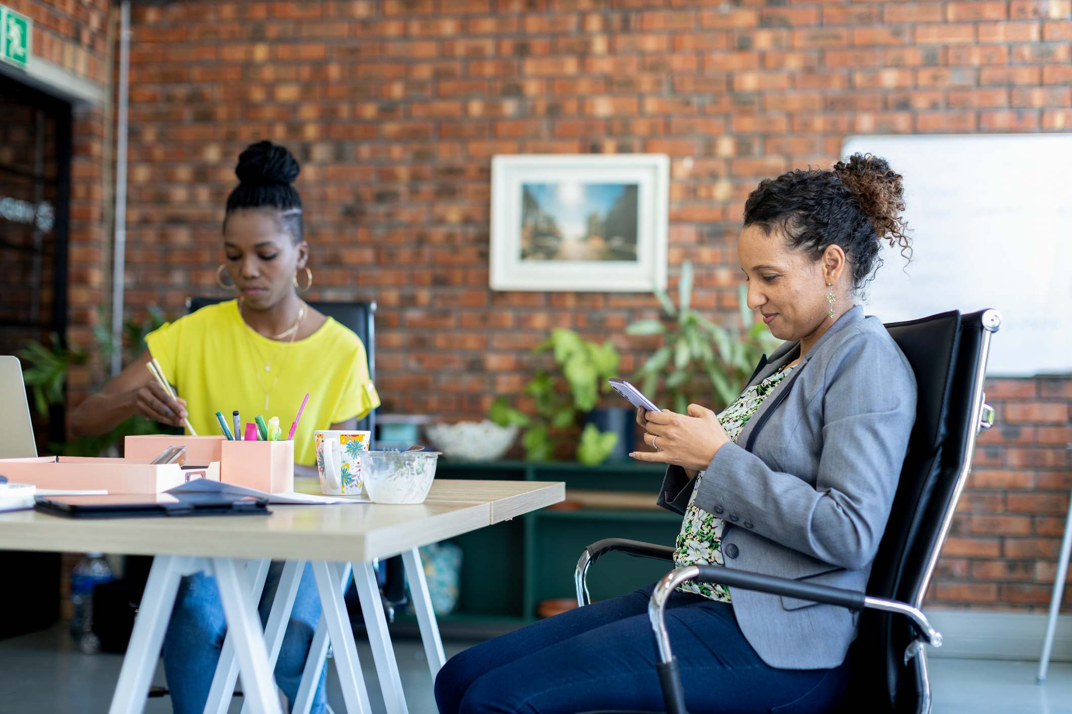 Women-looking-at-smart-phones-together-in-a-modern-creative-office-how-to-increase-attention-span