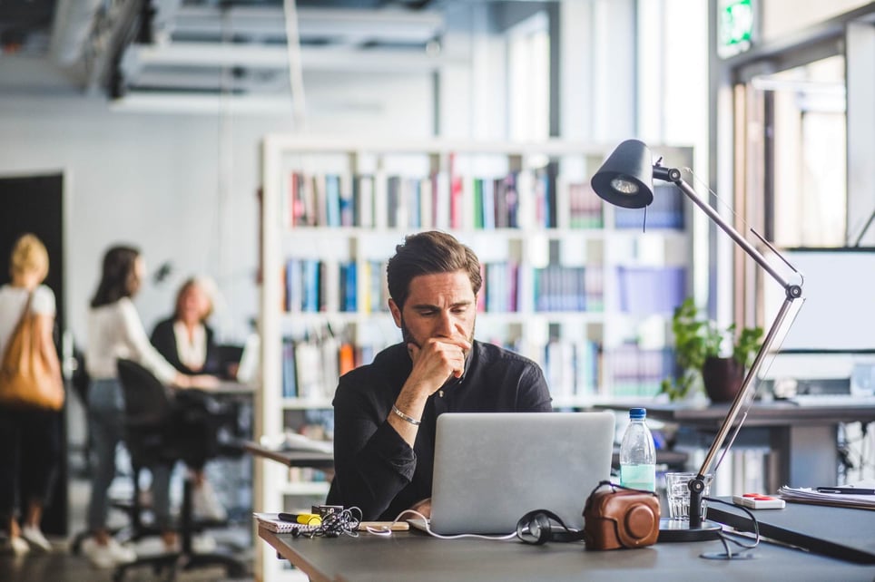 Worried-businessman-with-hand-on-chin-looking-at-laptop-what-to-do-if-you-don 't-get-a-promotion