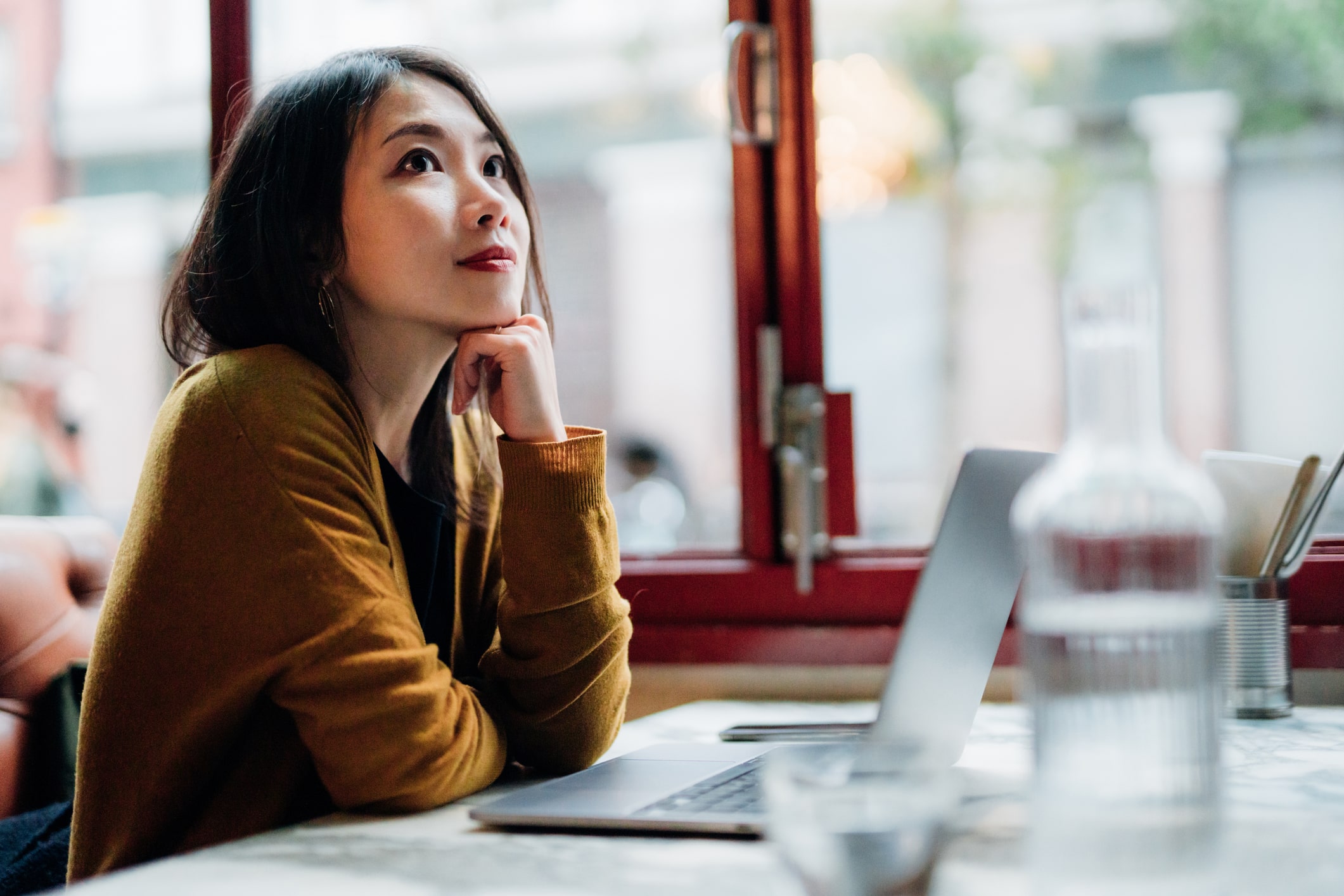 Young-Woman-Working-With-Laptop-At-Cafe-factors-that-promote-resilience