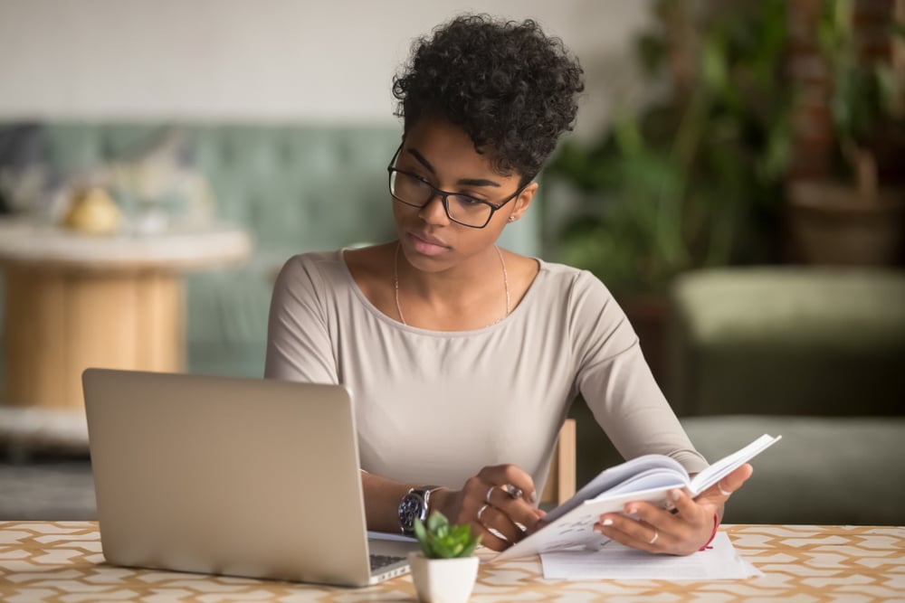 Young-business-woman-taking-notes-in-front-of-laptop-how-to-answer-salary-expectations