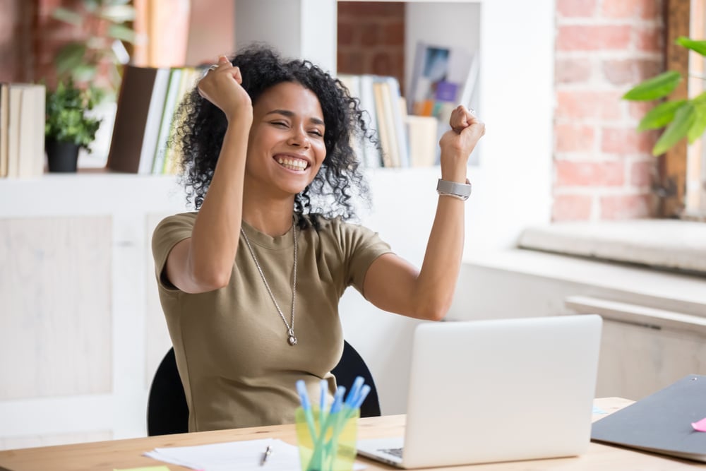 Young-female-celebrating-in-front-of-laptop-examples-of-motivation-and-inspiration