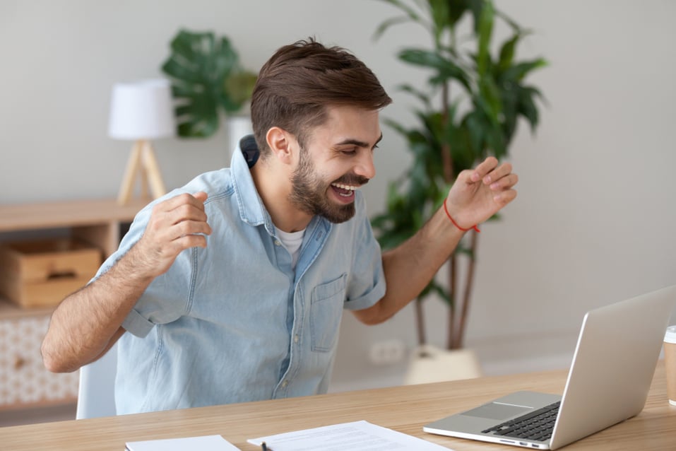 Young-man-happy-in-front-of-laptop-examples-of-motivation-and-inspiration