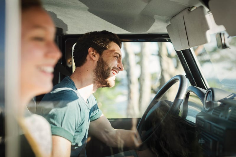 Young-man-laughing-and-driving-at-sunset-how-to-choose-my-own-life-path-as-a-millennial