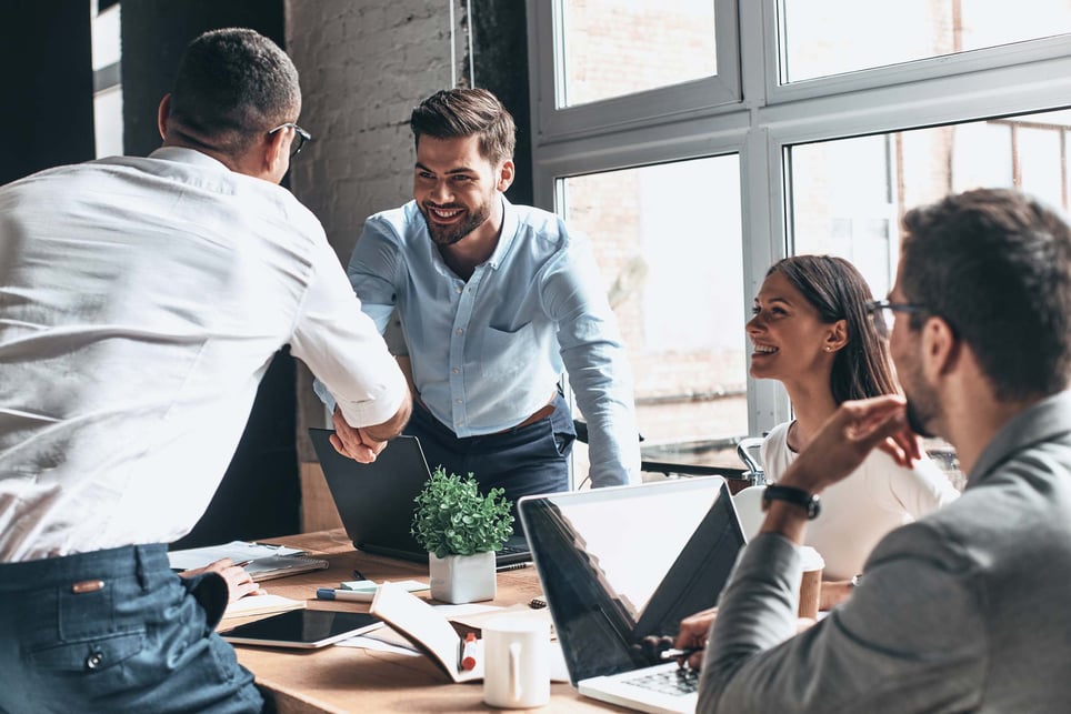 Young-modern-men-in-smart-casual-wear-shaking-hands-and-smiling-while-working-in-the-creative-office-how-to-introduce-yourself