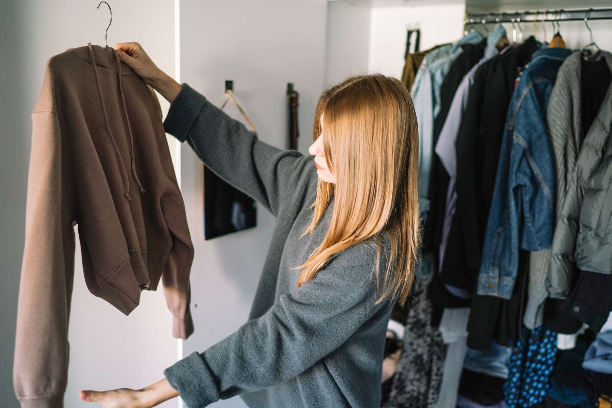 Young-woman-looking-at-clothes-in-her-wardrobe-spotlight-effect