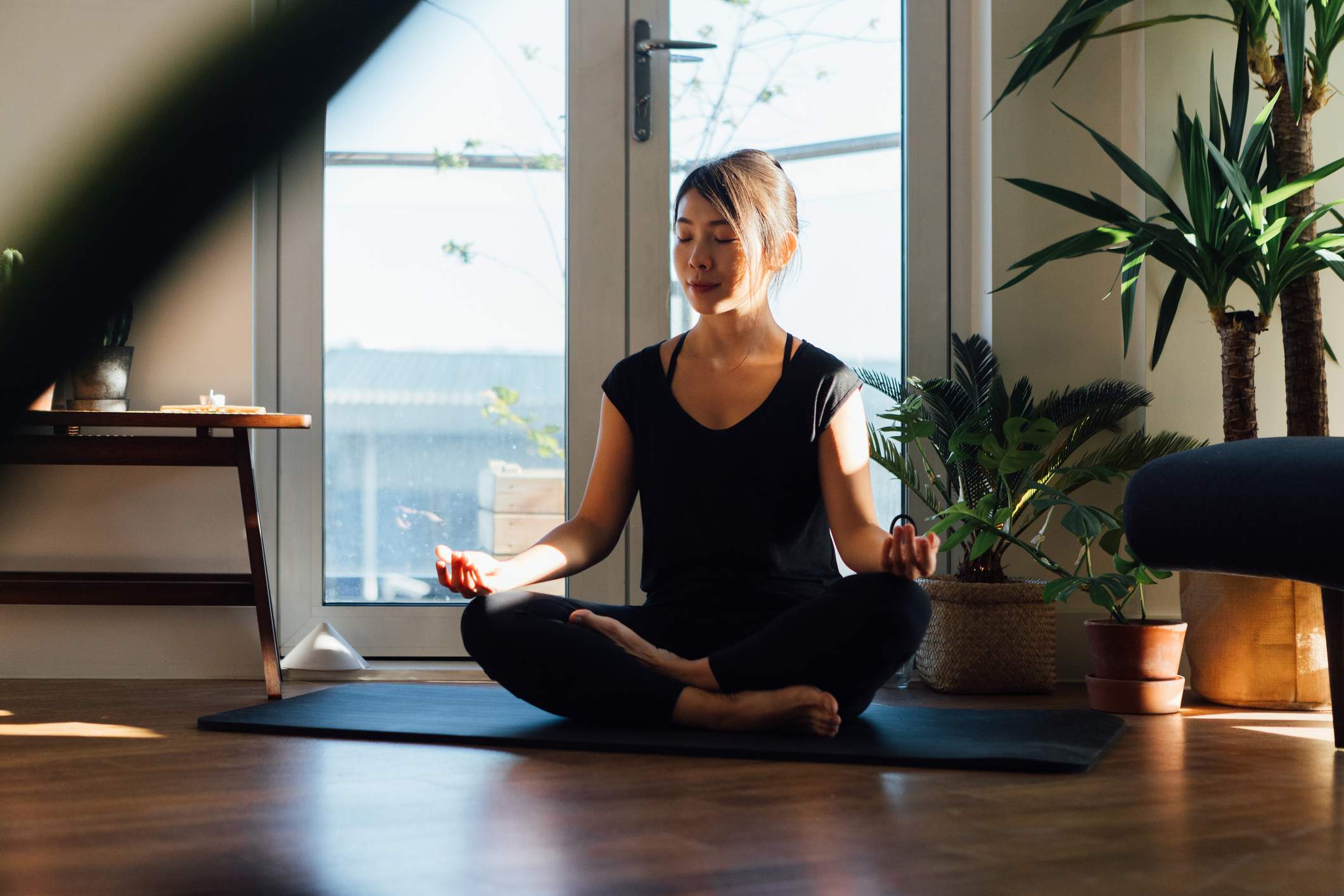 Young-woman-meditating-while-sitting-at-home-purpose-of-anger-emotion