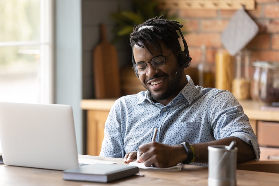 afro-man-using-headphones-and-writing-down-most-in-demand-jobs