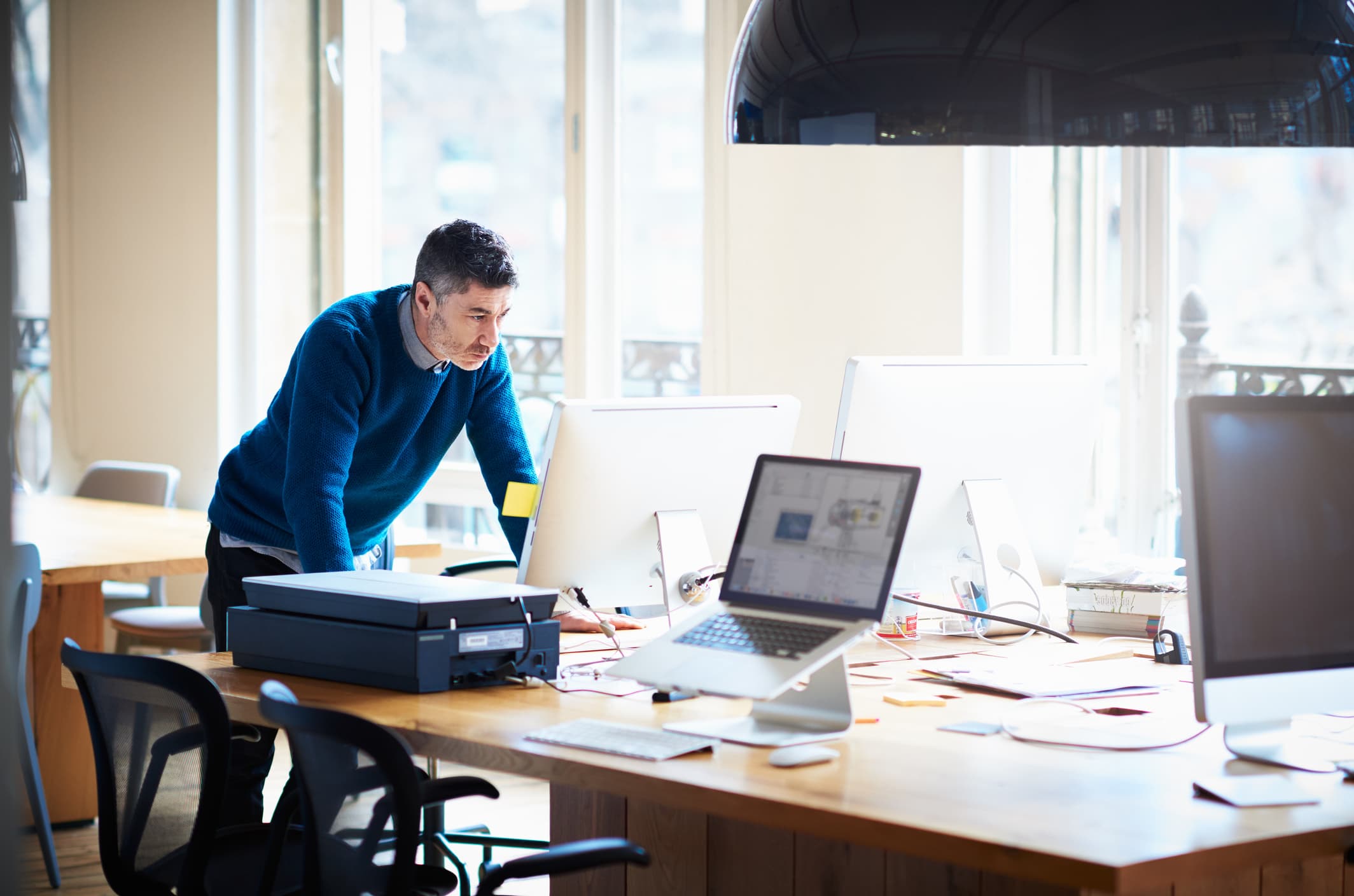 businessman-standing-by-desk