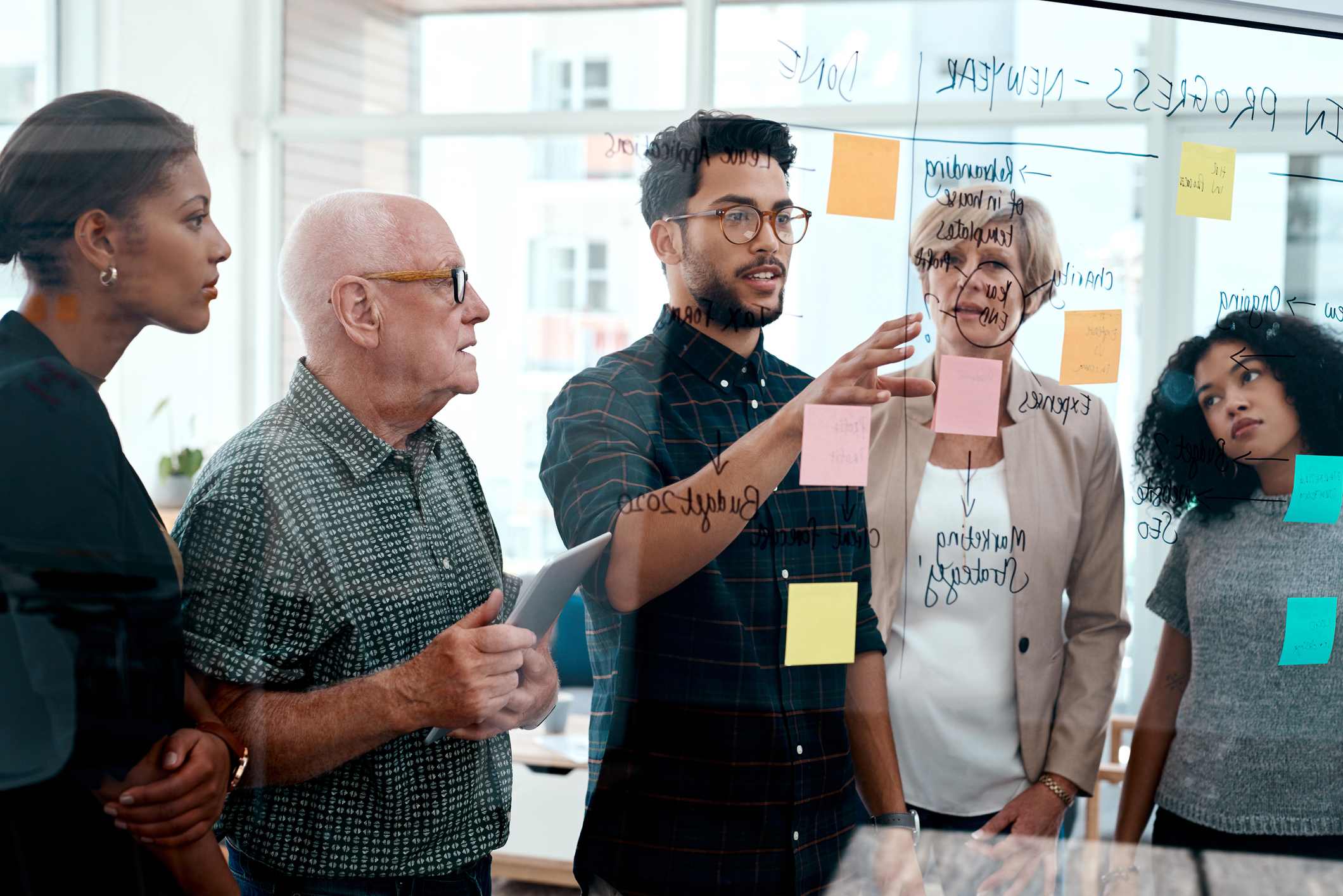 businesspeople-brainstorming-with-notes-on-a-glass-wall-fast-paced-environment