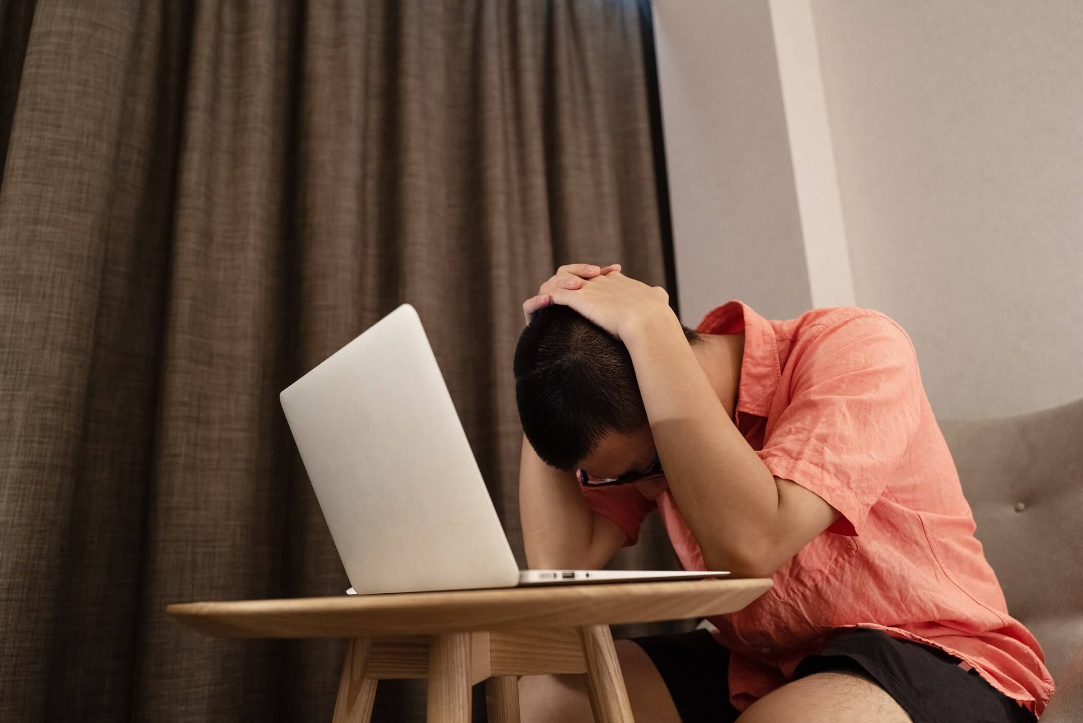 destraught-man-leaning-over-computer