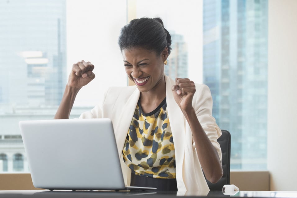 excited-businesswoman-on-her-laptop-how-motivation-helps-in-achieving-goals