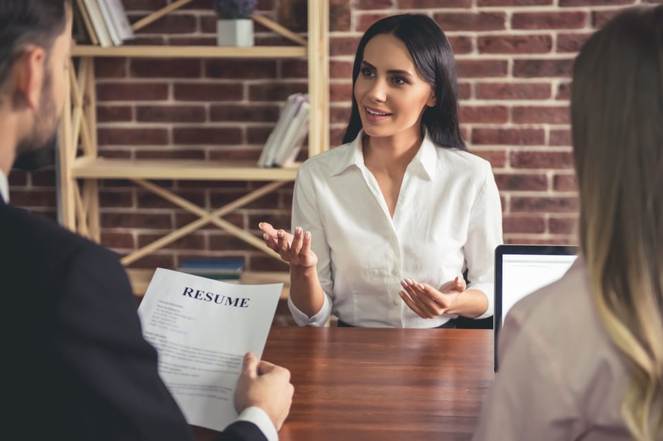 female-employee-in-suit-is-smiling-during-the-job-interview-action-verbs-for-resume