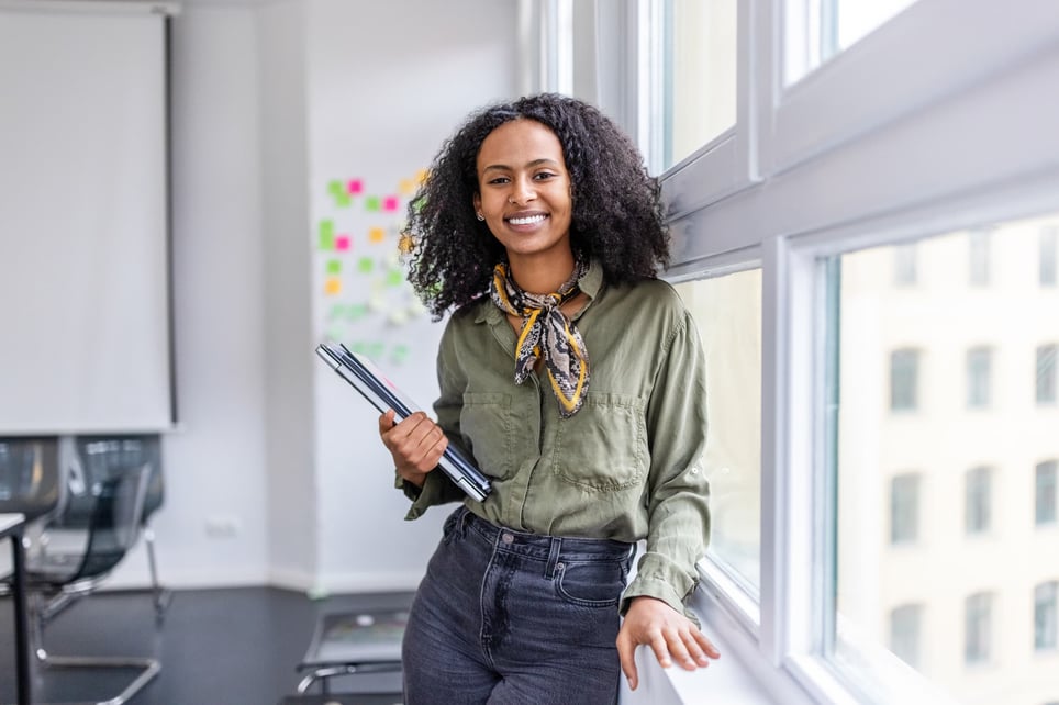 female-worker-smiling-in-the-office-how-to-make-yourself-indispensable-at-work