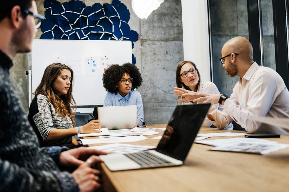 group-of-people-working-together-in-boardroom-how-to-make-yourself-indispensable-at-work