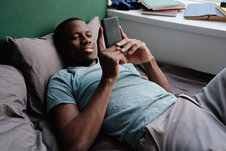 man-looking-at-cellphone-in-bed-circadian-rhythms