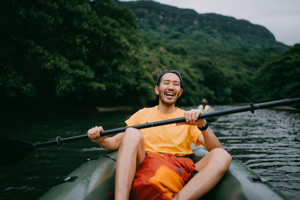 man-paddling-packraft-in-mangrove-river-and-laughing, -reasons-to-take-a-vacation