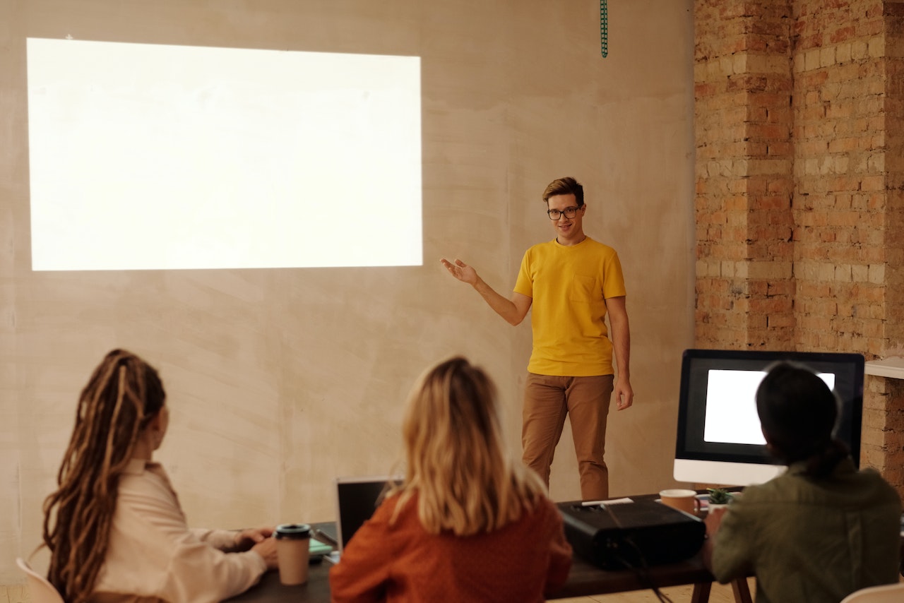 man-pointing-at-screen-during-presentation-how-to-make-a-presentation-interactive