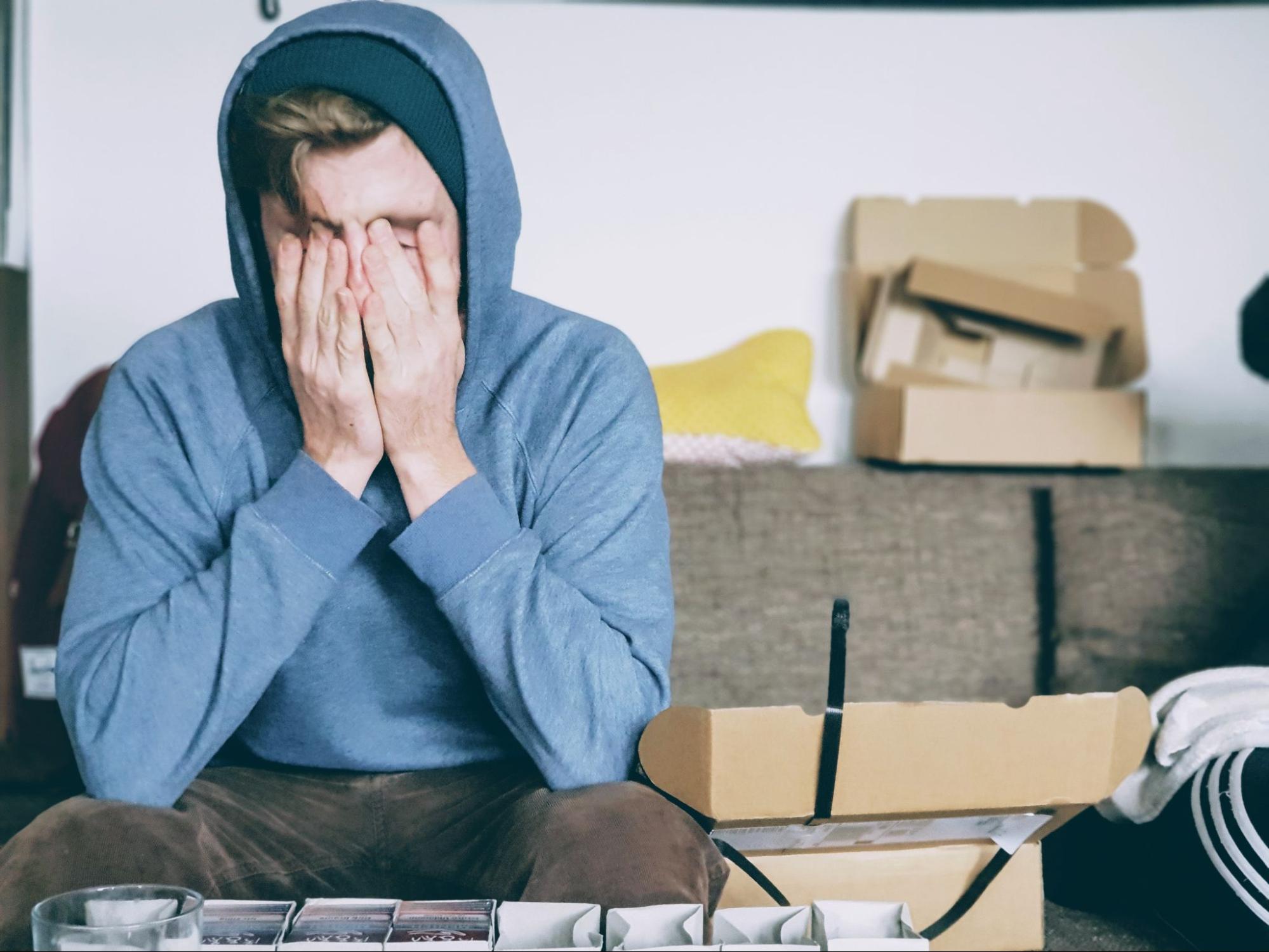 man-sits-with-face-in-hands-surrounded-by-boxes-stress-management-techniques