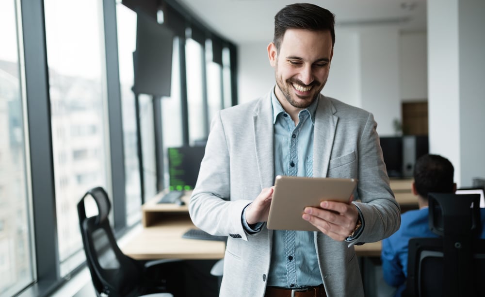 man-smiling-at-his-tablet-what-is-an-action-plan