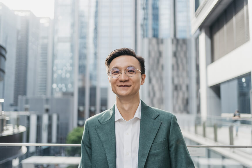 man-smiling-in-front-of-city-buildings-reward-power