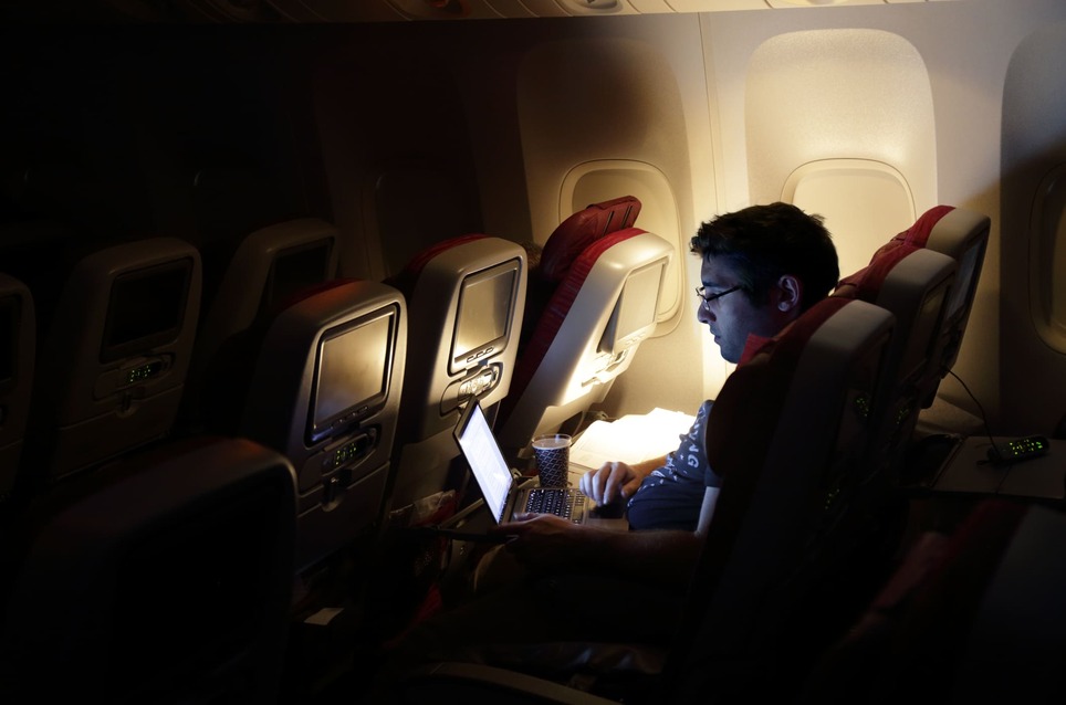 man-working-on-his-laptop-on-plane-what-to-do-when-you-cant-stop-working