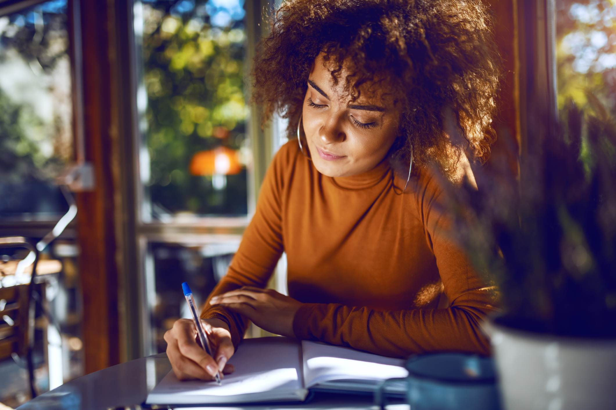 student-with-curly-hair-and-in-turtleneck-sitting-in-cafe-how-to-quit-a-part-time-job