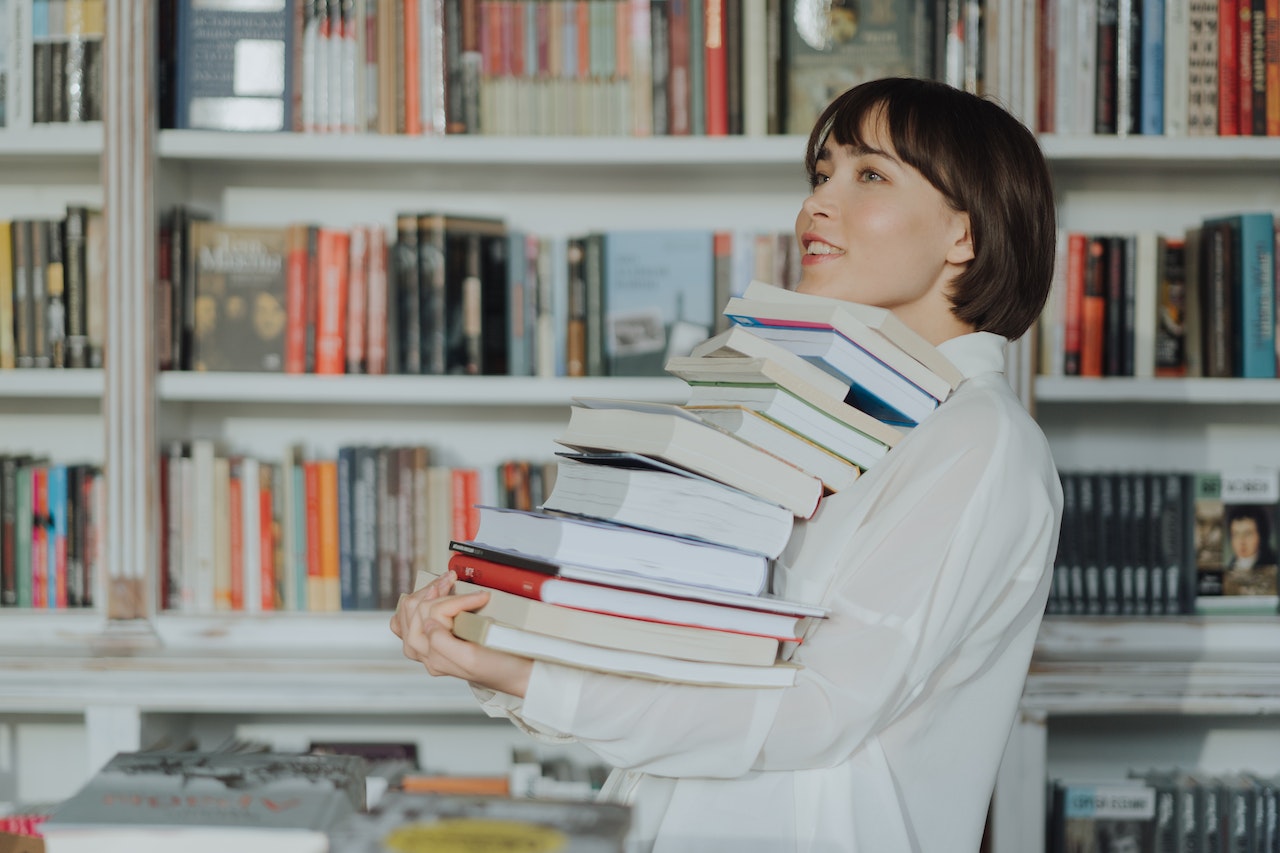 woman-carrying-a-pile-of-books-cell-phone-addiction