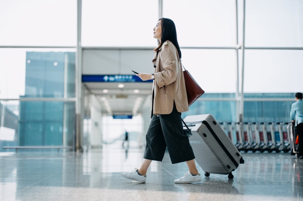 woman-carrying-suitcase-and-walking-in-airport-terminal-reasons-to-take-a-vacation