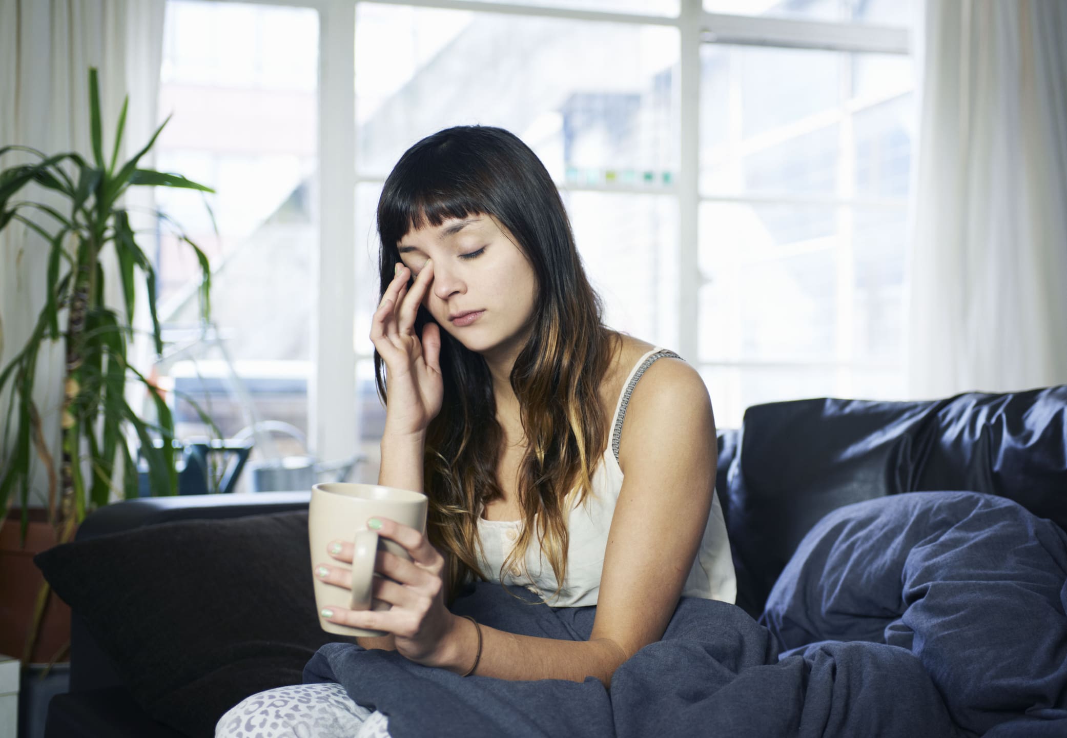 woman-looking-tired-sitting-on-sofa-how-to-use-music-to-concentrate