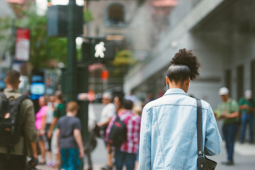 woman-walking-in-city-with-headphones-chronic-stress