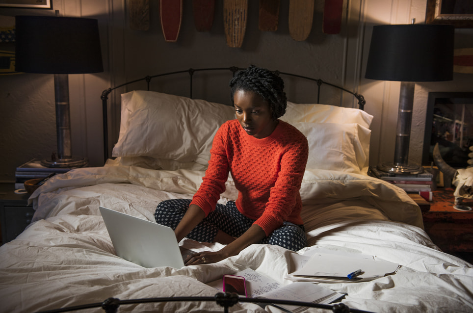 woman-working-late-at-night-on-her-bed-what-causes-perfectionism