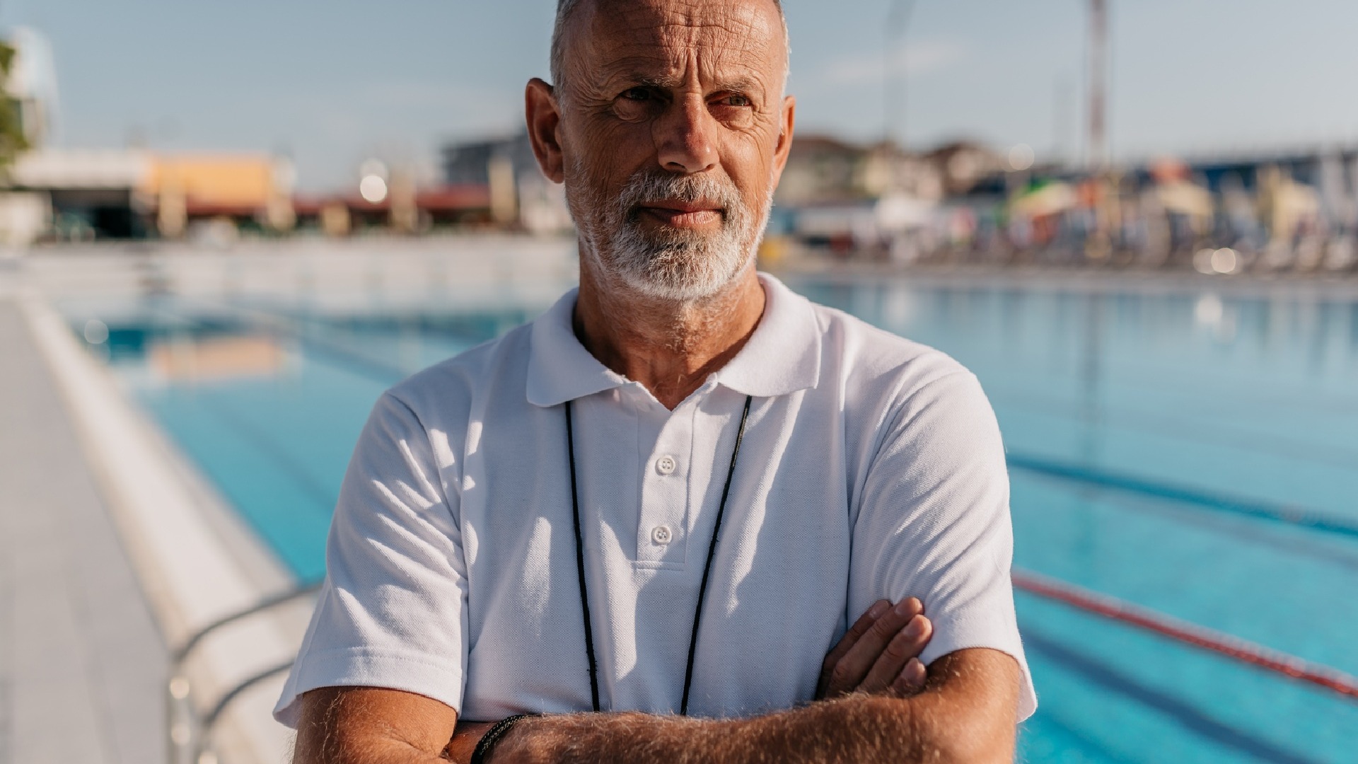 gray-haired-coach-with-arms-folded-you-need-a-coach