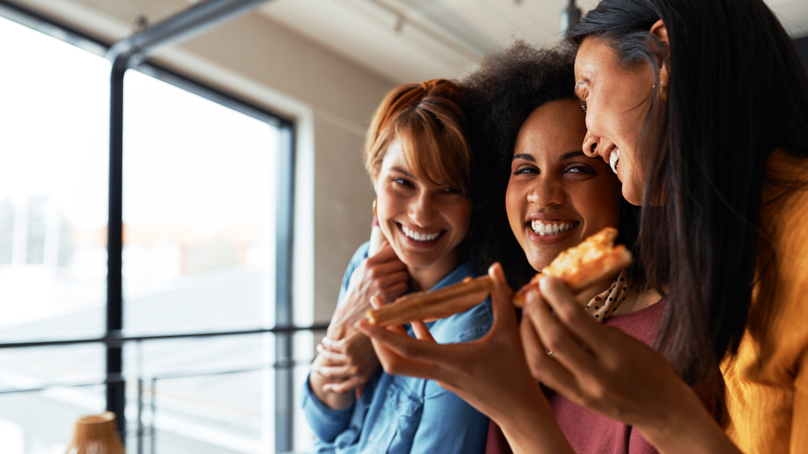 three-women-laugh-sharing-a-snack-nutrition-and-mental-health-blog